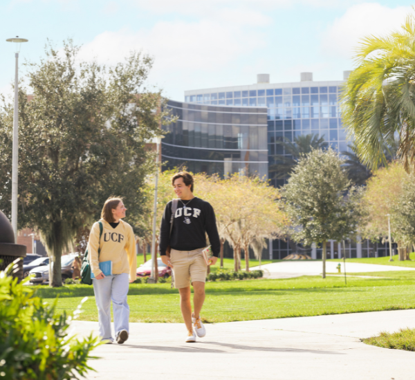 ucf teaching academy with a female and male student waking in the foreground toward the camera