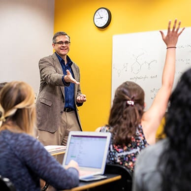 Professor teaching undergraduate students in a classroom.