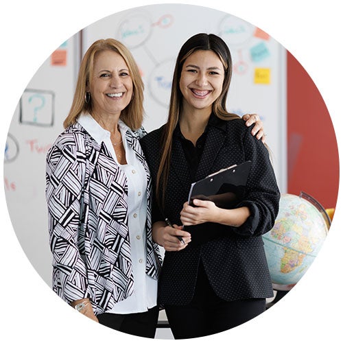 Educators in front of a globe and whiteboard.