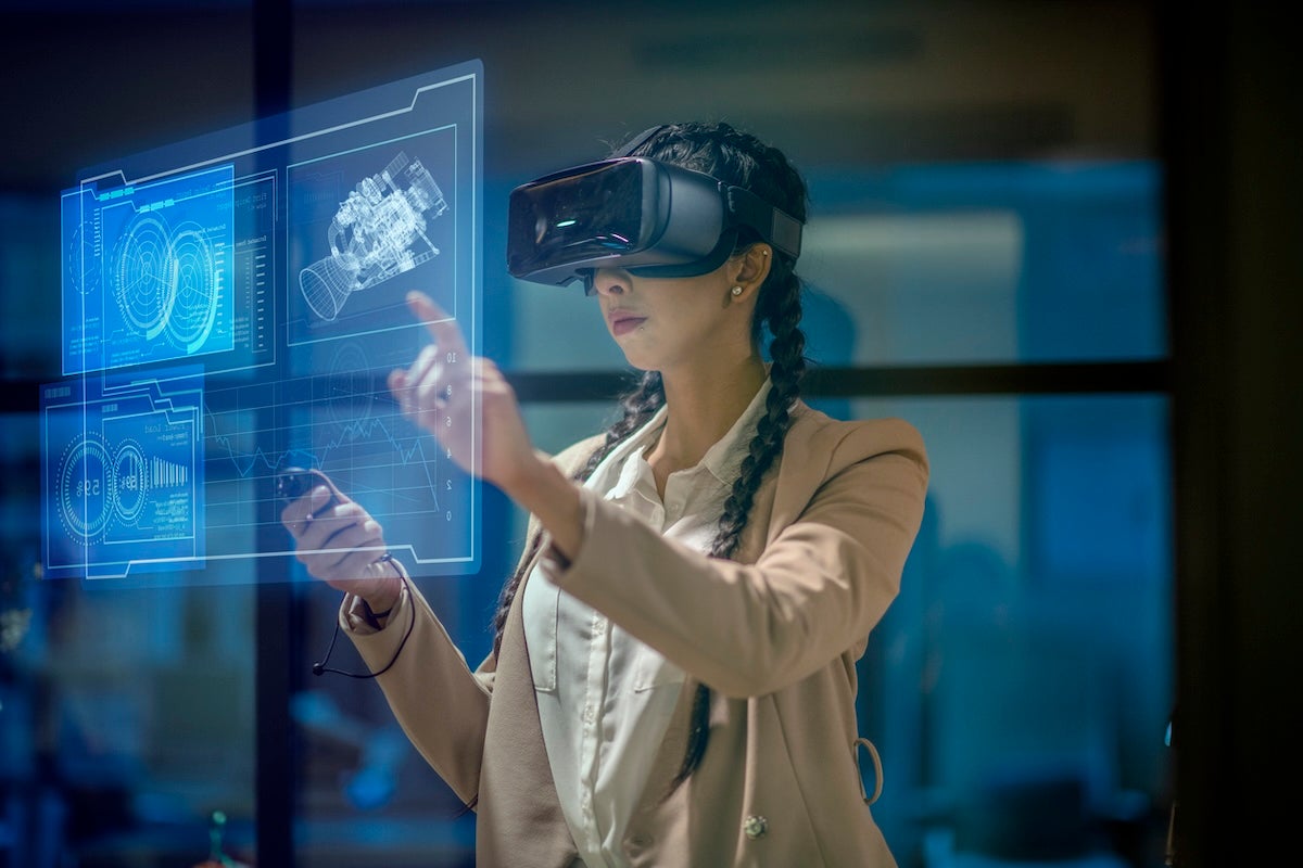 Female engineer wearing a virtual reality headset at work to explore an upcoming mechanical engineering project. She uses her hands to manipulate and explore the finer details.