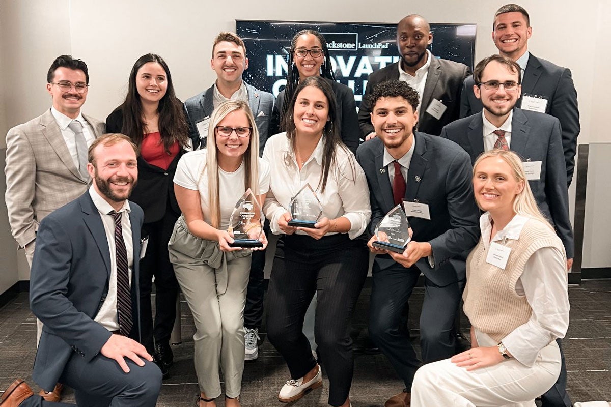 A group of people posing for a photo and holding awards