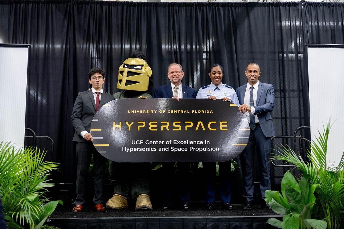 A group of people and UCF Mascot on stage holding a sign that says "Hyperspace UCF_Center of Excellence in Hypersonic and Space Propulsion)