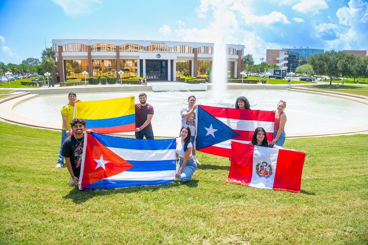 Students holding flags from various Hispanic nations.