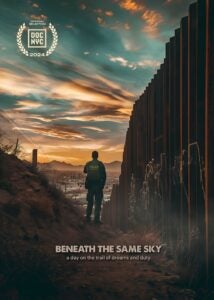 A movie poster with a border patrol officer standing next to the U.S.-Mexico wall