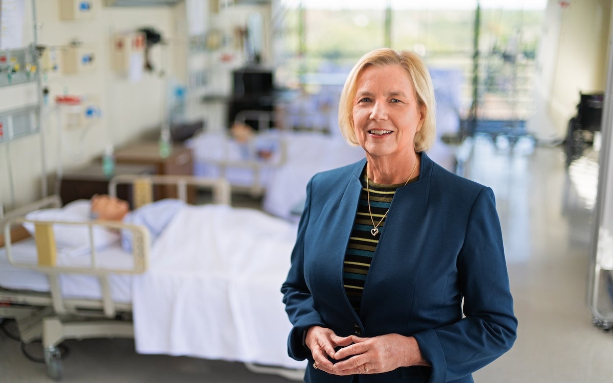 Mary Lou Sole standing in a stimulation lab with manikins behind her