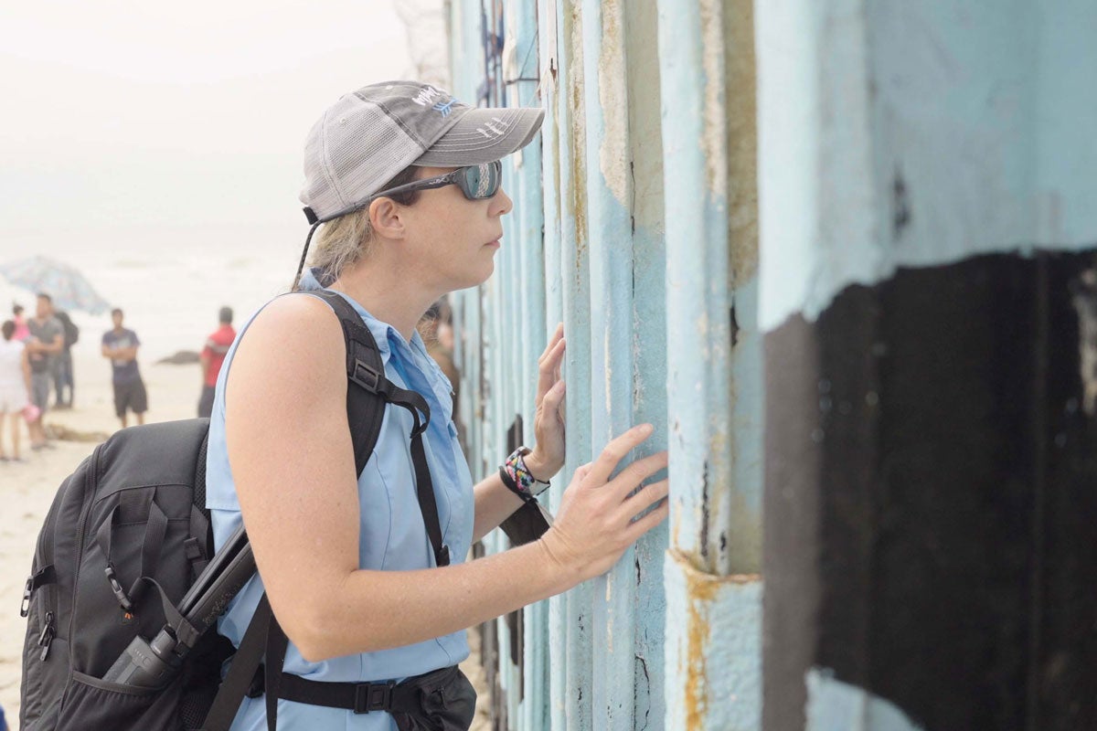 A woman looking through a fence