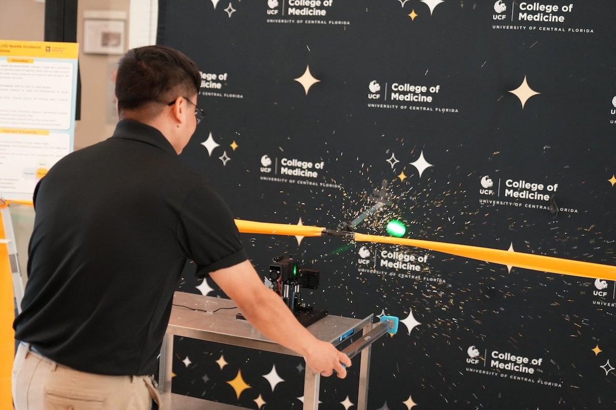 Someone using a laser to cut through a ribbon