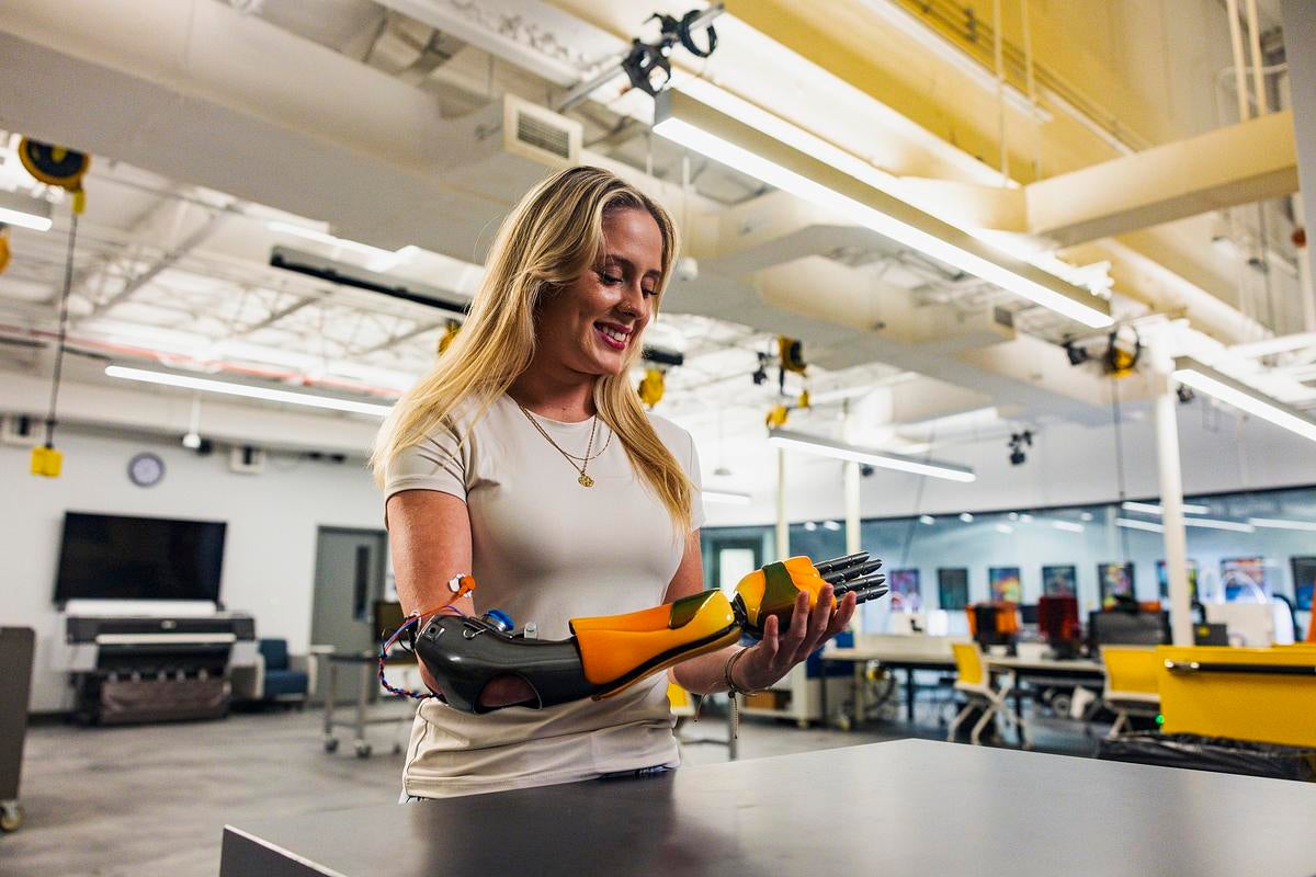 Health science student Annika Emmett tries on a bionic arm at the Limbitless Solutions office