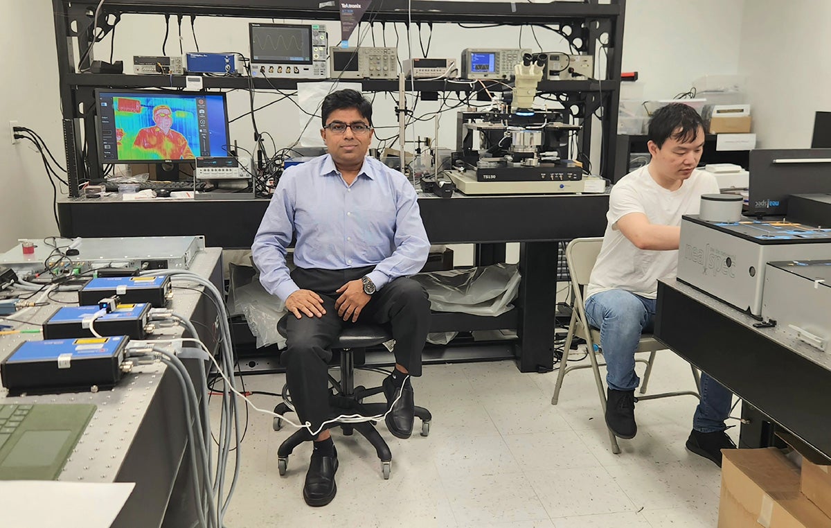 UCF NanoScience Technology Center Professor Debashis Chanda sits near an infrared camera image of himself in his lab. Chanda and his research group of UCF students developed a new long wave infrared detection technique. (Photo courtesy of Debashis Chanda)