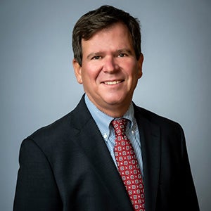 Headshot photo of a man wearing a suit