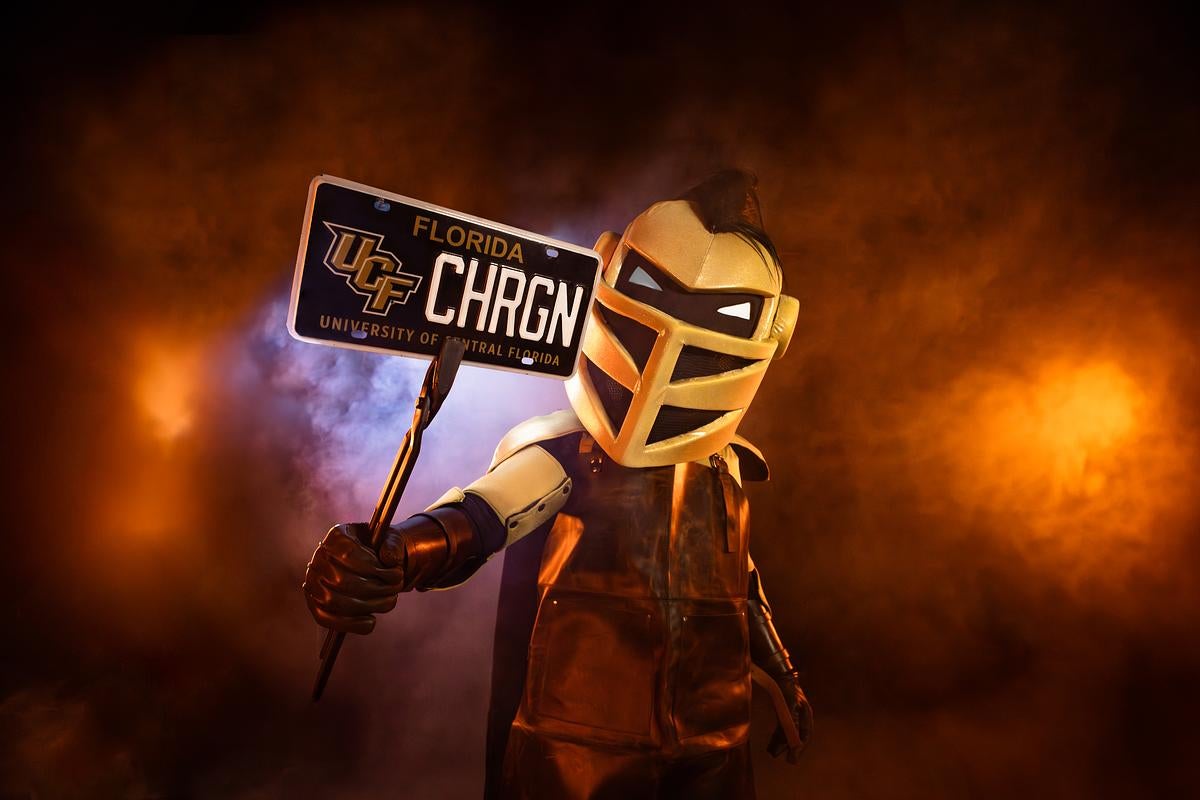 Knightro emerges from smoke holding a UCF speciality license plate 