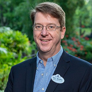 Headshot photo of a man wearing a suit