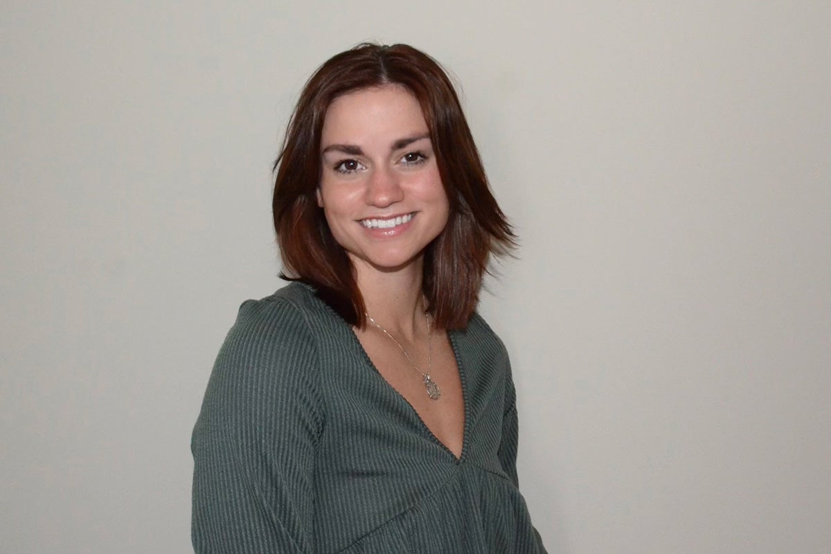 Woman poses in front of a white wall