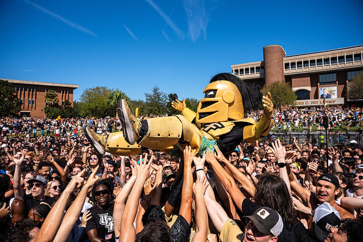 Knightro surfs over a crowd of students during Spirit Splash held at UCF's Reflecting Pond