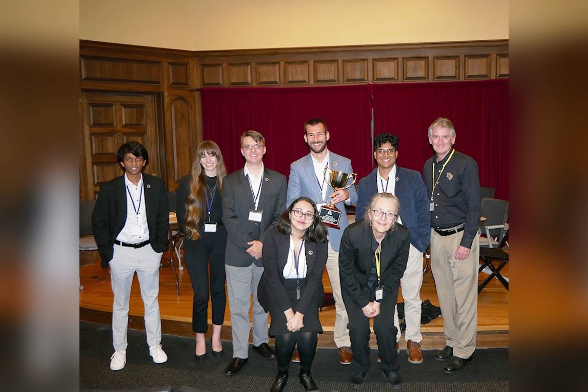 A group of students posing for a photo with a trophy.