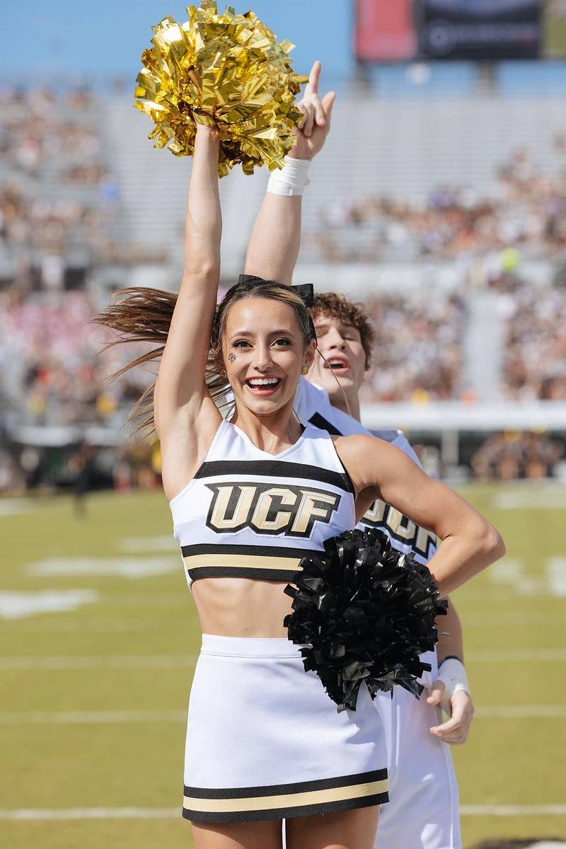 Two UCF cheerleaders performing on the sidelines at FBC Mortgage Stadium