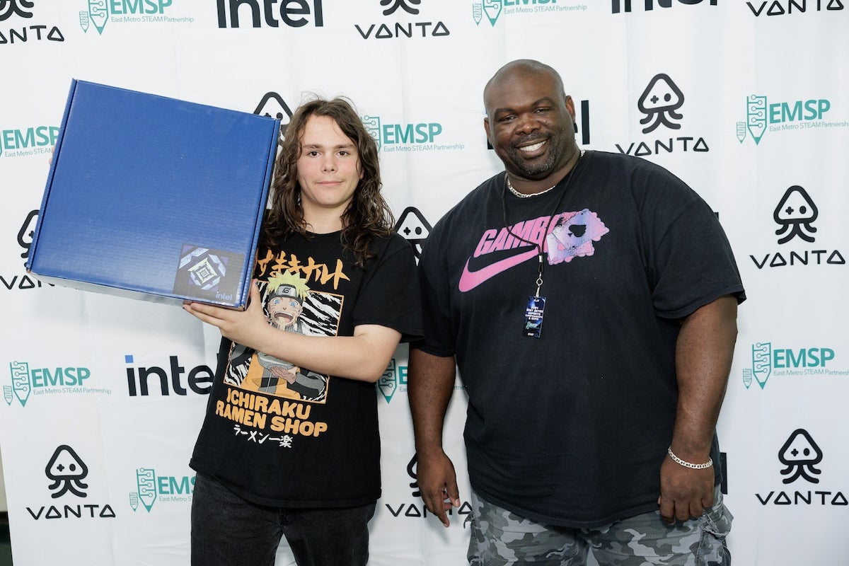 Corey Frazier standing next to a student holidng a box with Intel technology