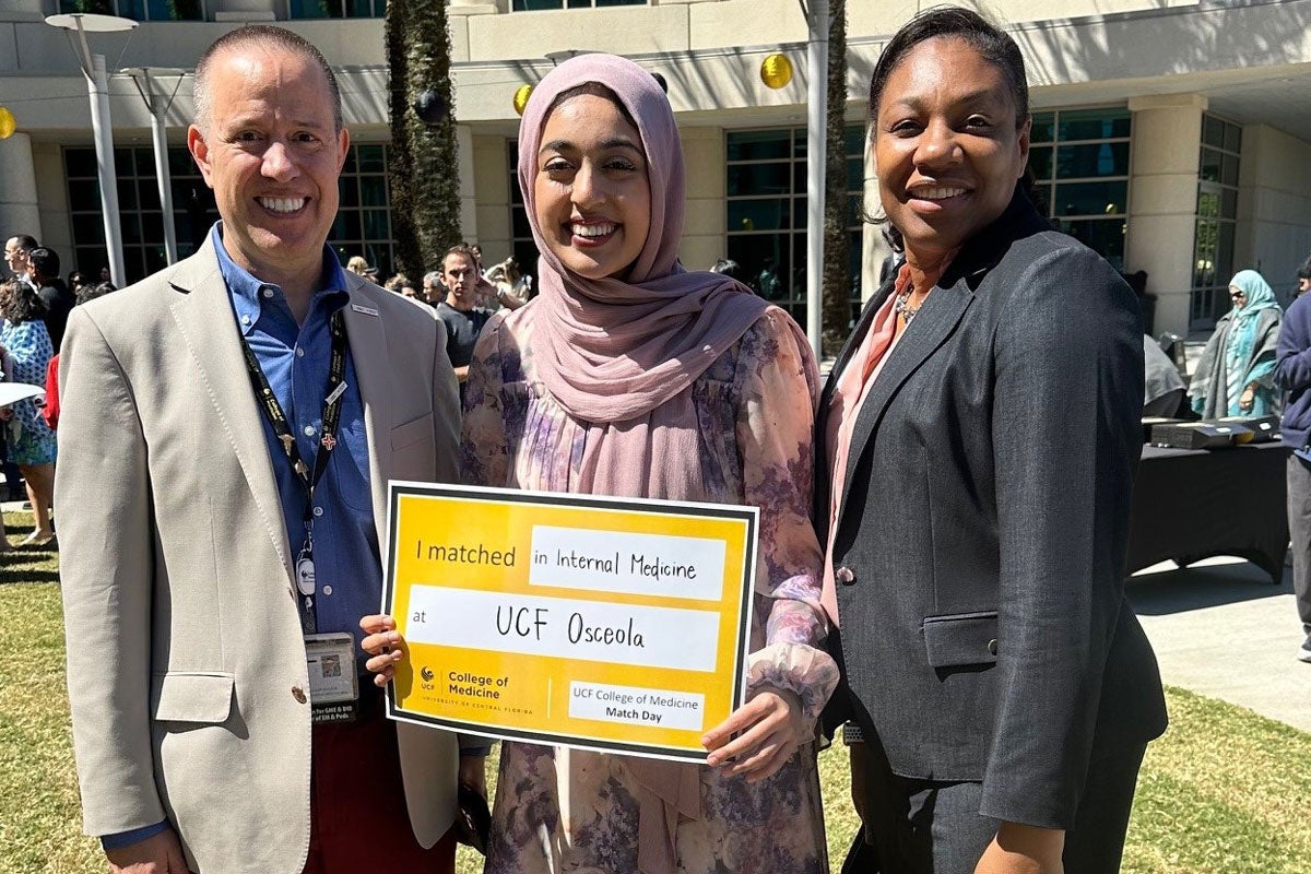 Hiba Nadeem (center) with Stephen Cico, UCF’s associate dean for graduate medical education, and Cheryll Albold, vice president for GME for the UCF-HCA Florida Healthcare consortium and HCA’s North Florida Division.